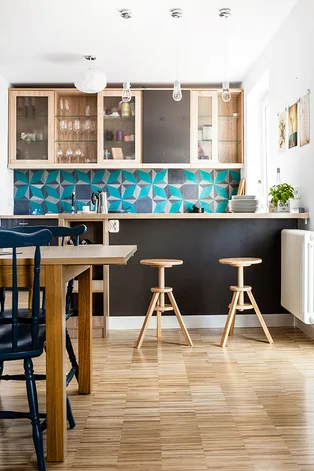 A kitchen with turquoise geometric tiles